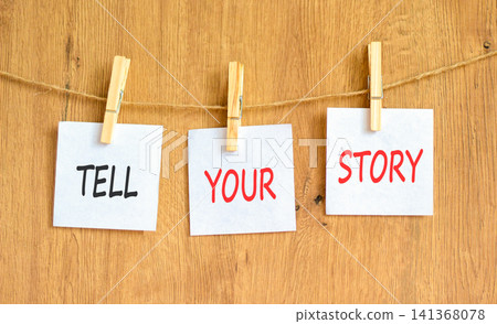 Tell your story symbol. Concept word Tell your story on beautiful white papers on wooden clothespin. Beautiful wooden background. Business tell your story concept. Copy space. Tell your story symbol. Concept word Tell your story on beautiful white papers on wooden clothespin. Beautiful wooden background. Business tell your story concept. Copy space. 141368078
