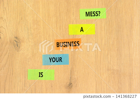 Is your business a mess symbol. Concept words Is your business a mess on beautiful colored papers. Beautiful wooden background. Is your business a mess concept. Copy space. 141368227