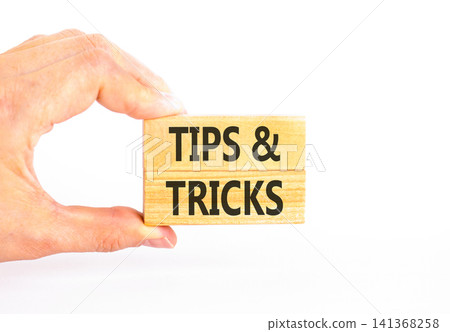 Tips and tricks words symbol. Concept words Tips and tricks on beautiful wooden blocks. Beautiful white background. Businessman hand. Business tips and tricks motivational support concept. Copy space Tips and tricks words symbol. Concept words Tips and tricks on beautiful wooden blocks. Beautiful white background. Businessman hand. Business tips and tricks motivational support concept. Copy space 141368258
