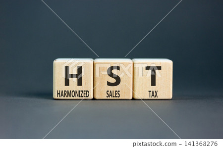 HST harmonized sales tax symbol. Concept words HST harmonized sales tax on beautiful wooden blocks. Beautiful grey background. Business HST harmonized sales tax concept. Copy space HST harmonized sales tax symbol. Concept words HST harmonized sales tax on beautiful wooden blocks. Beautiful grey background. Business HST harmonized sales tax concept. Copy space 141368276