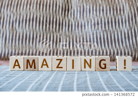 motivational word Amazing! made of letters on wooden cubes motivational word Amazing! made of letters on wooden cubes 141368572