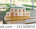 motivational phrase Take Action made of letters on wooden cubes 141368658