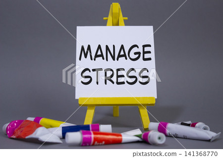 Manage stress symbol. Concept word Manage stress on wooden blocks. Beautiful grey background with paints and easel. Business and Manage stress concept. Copy space Manage stress symbol. Concept word Manage stress on wooden blocks. Beautiful grey background with paints and easel. Business and Manage stress concept. Copy space 141368770
