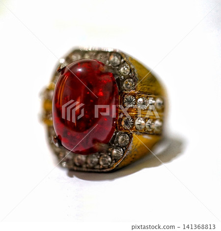 Gold Ring With Large Red Ruby Cabochon and Diamond Accent Stones Jewelry Close-Up Gold Ring With Large Red Ruby Cabochon and Diamond Accent Stones Jewelry Close-Up 141368813