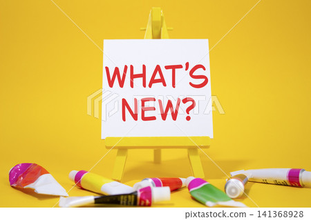 What is new symbol. Concept word What is new on wooden blocks. Beautiful yellow background with paints and easel. Business and What is new concept. Copy space What is new symbol. Concept word What is new on wooden blocks. Beautiful yellow background with paints and easel. Business and What is new concept. Copy space 141368928
