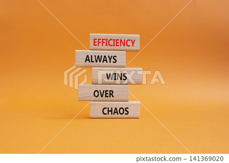Efficiency symbol. Wooden blocks with words Efficiency Always Wins Over Chaos. Beautiful orange background. Businessman hand. Business and Efficiency concept. Copy space Efficiency symbol. Wooden blocks with words Efficiency Always Wins Over Chaos. Beautiful orange background. Businessman hand. Business and Efficiency concept. Copy space 141369020