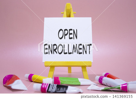 Open Enrollment symbol. Wooden blocks with words Open Enrollment. Beautiful pink background with paints and easel. Business and Open Enrollment concept. Copy space. Open Enrollment symbol. Wooden blocks with words Open Enrollment. Beautiful pink background with paints and easel. Business and Open Enrollment concept. Copy space. 141369155