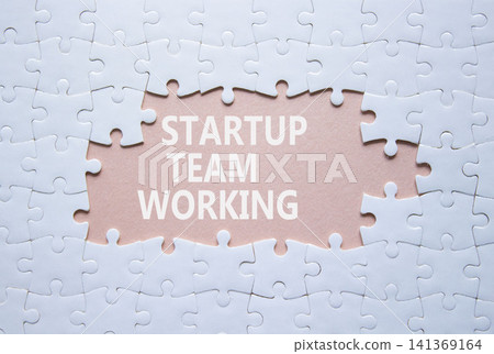 Startup Team Working symbol. White puzzle with words Startup Team Working. Beautiful pink background. Business concept. Copy space. Startup Team Working symbol. White puzzle with words Startup Team Working. Beautiful pink background. Business concept. Copy space. 141369164