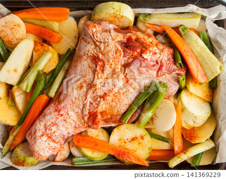 Fresh raw marinated turkey leg in baking pan with potatoes, carrots, onion and squash before oven Fresh raw marinated turkey leg in baking pan with potatoes, carrots, onion and squash before oven 141369229