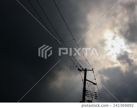 Sunlight is shining through the clouds, revealing their outlines, but most of the sky is covered in somewhat thick, opaque clouds. Sunlight is shining through the clouds, revealing their outlines, but most of the sky is covered in somewhat thick, opaque clouds. 141369892