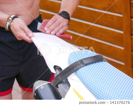 Man sanding motorcycle plastic bodywork part. Mechanic repairing bike components. Maintenance of vehicle parts. DIY garage workshop project. Professional repair service concept at work. Man sanding motorcycle plastic bodywork part. Mechanic repairing bike components. Maintenance of vehicle parts. DIY garage workshop project. Professional repair service concept at work. 141370278