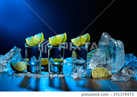 Tequila served with lime wedges, salt and crushed ice. Tequila served with lime wedges, salt and crushed ice. 141370473