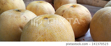 A close-up view of a fresh, ripe cantaloupe melon with a netted-textured surface. A close-up view of a fresh, ripe cantaloupe melon with a netted-textured surface. 141370523
