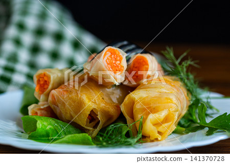 Delicious marinated cabbage rolls served with fresh lettuce leaves Delicious marinated cabbage rolls served with fresh lettuce leaves 141370728