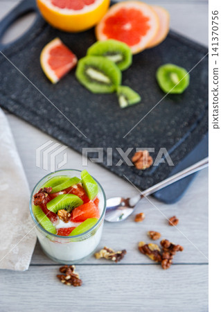 creamy yogurt with kiwi grapefruit and walnut topping closeup creamy yogurt with kiwi grapefruit and walnut topping closeup 141370756