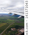 View of airplane wing above clouds on a clear sunny day with blue sky 141371043