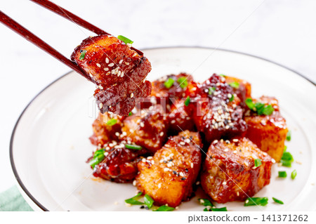 Chinese-style meat with sesame seeds and green onions, on a white plate, marble table, homemade, no people, Chinese-style meat with sesame seeds and green onions, on a white plate, marble table, homemade, no people, 141371262