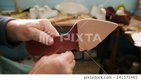 Artisan occupation. Footwear industry. Professional craftsman hands working with leather material shoe sole at workplace. Artisan occupation. Footwear industry. Professional craftsman hands working with leather material shoe sole at workplace. 141371465