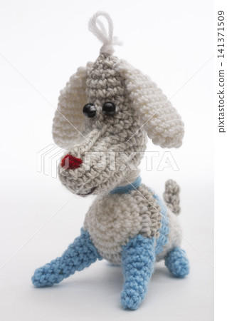 Knitted woolen dog on a white background Knitted woolen dog on a white background 141371509
