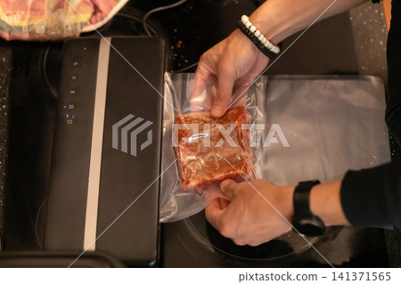 Chef Holding Vacuum Sealed Marinated Pork Rib Near Sealer 141371565