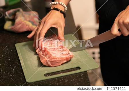 Chef Slicing Raw Pork Ribs With Large Kitchen Knife Board 141371611