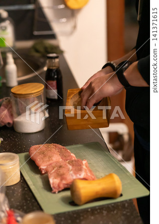 Chef Holding Mortar Seasoning Raw Pork on Cutting Board Chef Holding Mortar Seasoning Raw Pork on Cutting Board 141371615