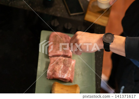 Overhead View Seasoned Raw Pork Pieces on Cutting Board 141371617