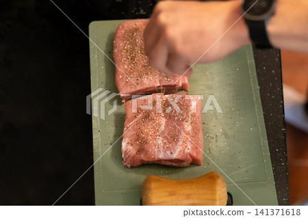 Overhead View Seasoned Raw Pork Pieces on Cutting Board Overhead View Seasoned Raw Pork Pieces on Cutting Board 141371618