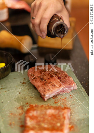 Two Marinated Raw Pork Pieces With Red Rub on Cutting Board Two Marinated Raw Pork Pieces With Red Rub on Cutting Board 141371628
