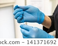 Syringe drawing medication from vial for injection 141371692