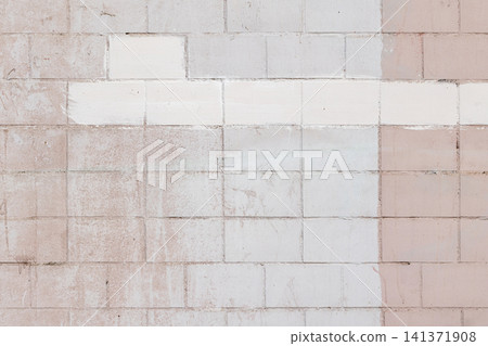 Faded pink and white painted cinderblock wall with visible texture 141371908