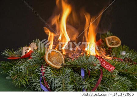 Christmas wreath completely engulfed in open flames after festive decorations caught fire indoors. 141372000