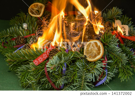Intense burning of a Christmas wreath demonstrates the danger of using open flames near dry evergreen branches. Intense burning of a Christmas wreath demonstrates the danger of using open flames near dry evergreen branches. 141372002