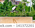 A young man practicing BMX and performing tricks at the skatepark 141372201