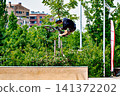 A young man practicing BMX and performing tricks at the skatepark 141372202