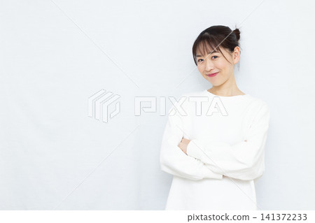 A woman thinking with her arms folded and a smile 141372233