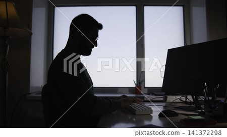 Man Coding Diligently. Focused Man Works At Desk. Concentrated Individual Types With Organized Setup. Media Man Coding Diligently. Focused Man Works At Desk. Concentrated Individual Types With Organized Setup. Media 141372298