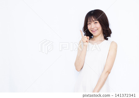 A woman who raises her index finger with a smile A woman who raises her index finger with a smile 141372341