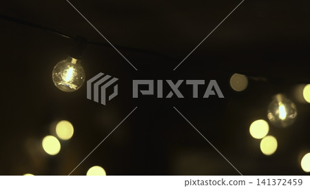 Outdoor Lights Set Romantic Mood. Cozy Garden Gathering Illuminated By Glowing Bulbs And Soft Focus . Media Outdoor Lights Set Romantic Mood. Cozy Garden Gathering Illuminated By Glowing Bulbs And Soft Focus . Media 141372459