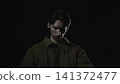 Solitary young man in dramatic low key lighting 141372477