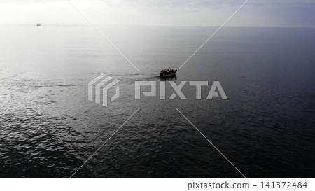 Tranquil Boat Scene Amid Shimmering Waters. Calm Seaside Fishing Operation Under Soft Sky Ambiance . Media Tranquil Boat Scene Amid Shimmering Waters. Calm Seaside Fishing Operation Under Soft Sky Ambiance . Media 141372484
