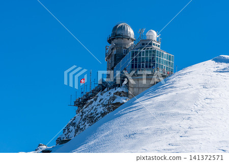 The Sphinx Observatory and astronomical tower perched on a cliff face. Lauterbrunnen, Bern, Switzerland. The Sphinx Observatory and astronomical tower perched on a cliff face. Lauterbrunnen, Bern, Switzerland. 141372571