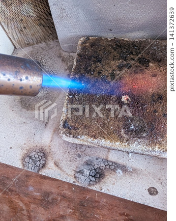 The blue flame of a gas torch and firebricks | Materials inspired by metalworking and crafting. The blue flame of a gas torch and firebricks | Materials inspired by metalworking and crafting. 141372639
