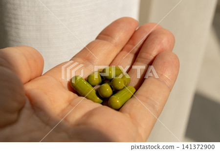 Green pills, herbal medicine capsules with herb powder Green pills, herbal medicine capsules with herb powder 141372900