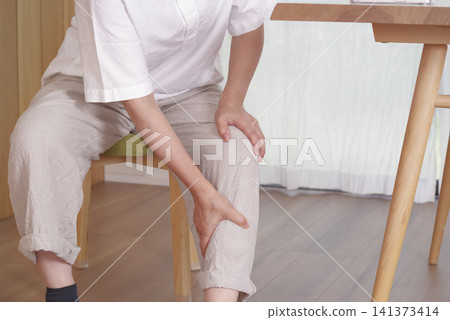 The hands of a middle-aged woman suffering from knee problems 141373414