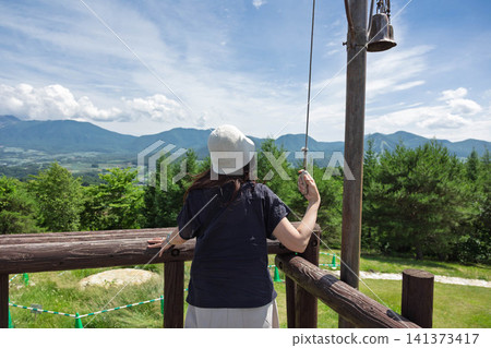 A woman ringing a bell on the hill of beloved wives, Tsumagoi Village, Gunma Prefecture. 141373417