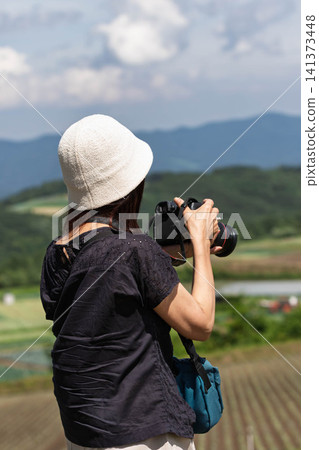 A woman photographs the scenery from Aisai no Oka (Wife's Hill) in Tsumagoi Village, Gunma Prefecture. A woman photographs the scenery from Aisai no Oka (Wife's Hill) in Tsumagoi Village, Gunma Prefecture. 141373448