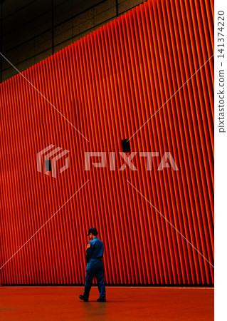A man walking inside a building A man walking inside a building 141374220