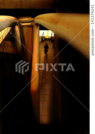 Walking along the passageway visible through the gaps between buildings 141374241