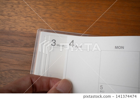 The hand that turns the page of the schedule book at the end of the fiscal year The hand that turns the page of the schedule book at the end of the fiscal year 141374474